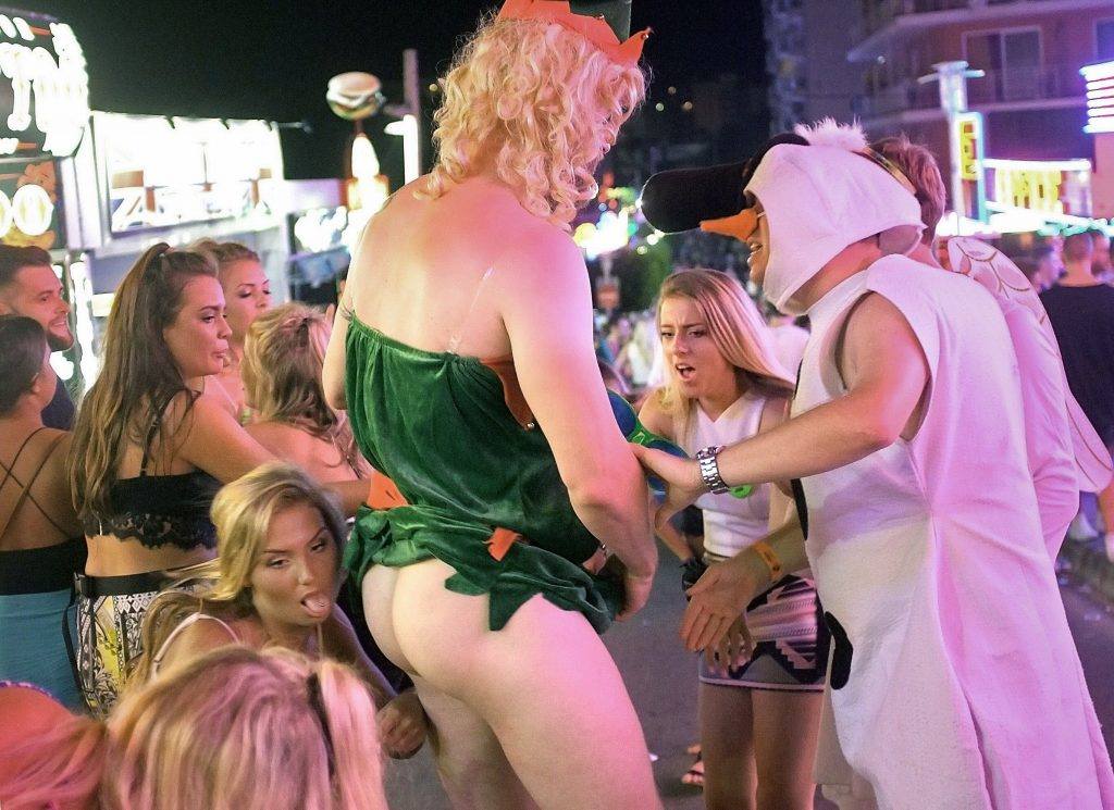 Some girls joke with a half-naked man in Punta Ballena street in Magaluf holiday resort in Calvia on the Spanish Mallorca Island on July 19, 2014. Known among some tourists as "Shagaluf, the resort has suffered particularly bad press over the past 12 months after a video showing a Northern Irish teenage girl performing sex acts on a group of men during a bar crawl went viral last summer. It is estimated 1 million Britons visit the region each year, bringing 800m ($866m) to the local economy, but the council is desperate to improve the reputation of destination, reported British journal The Guardian. AFP PHOTO / JAIME REINA